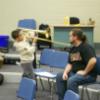 Brother McClannon helping a student with trombone